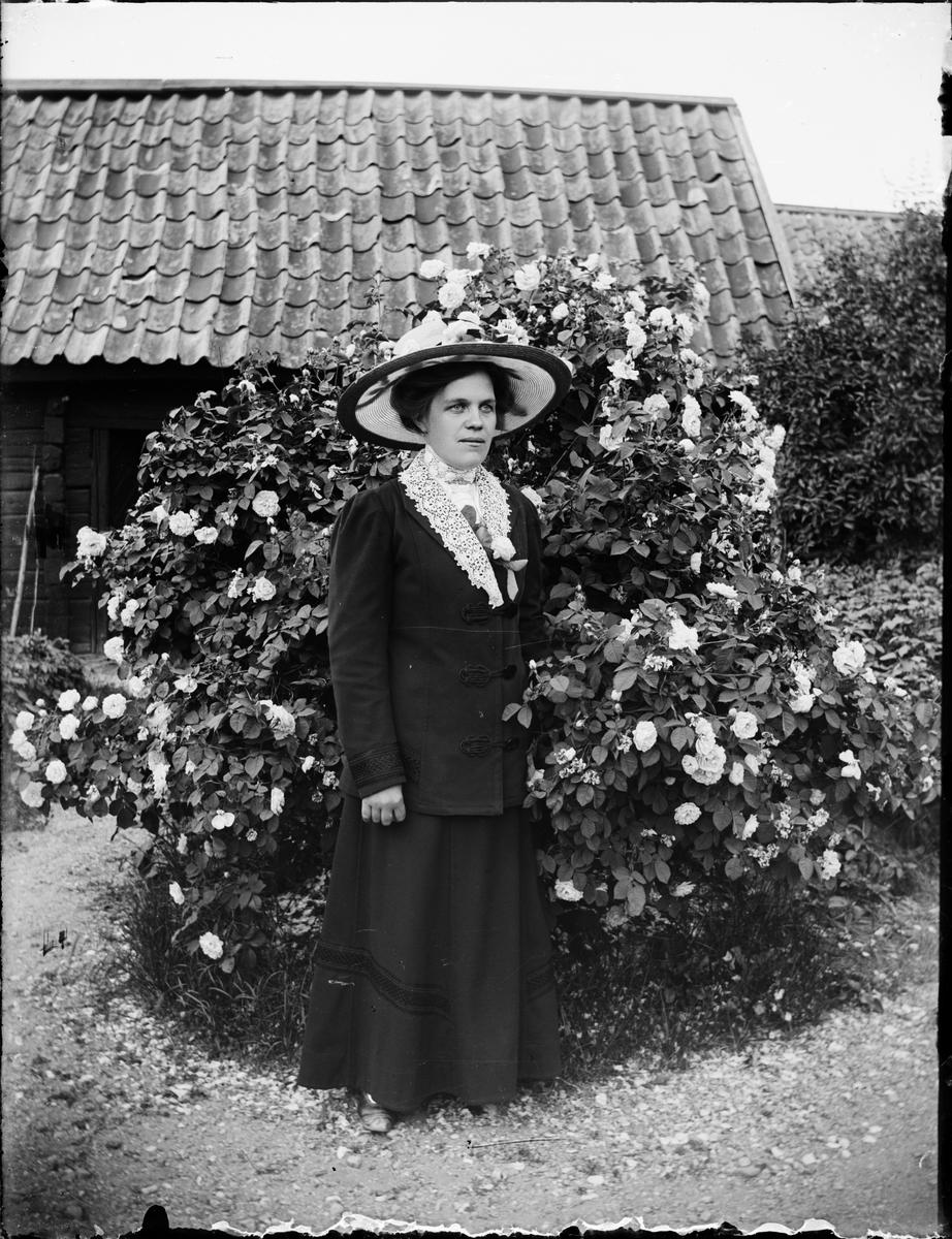 Skötsner-Edhlund, Kvinna framför en buske, Östhammar, Uppland