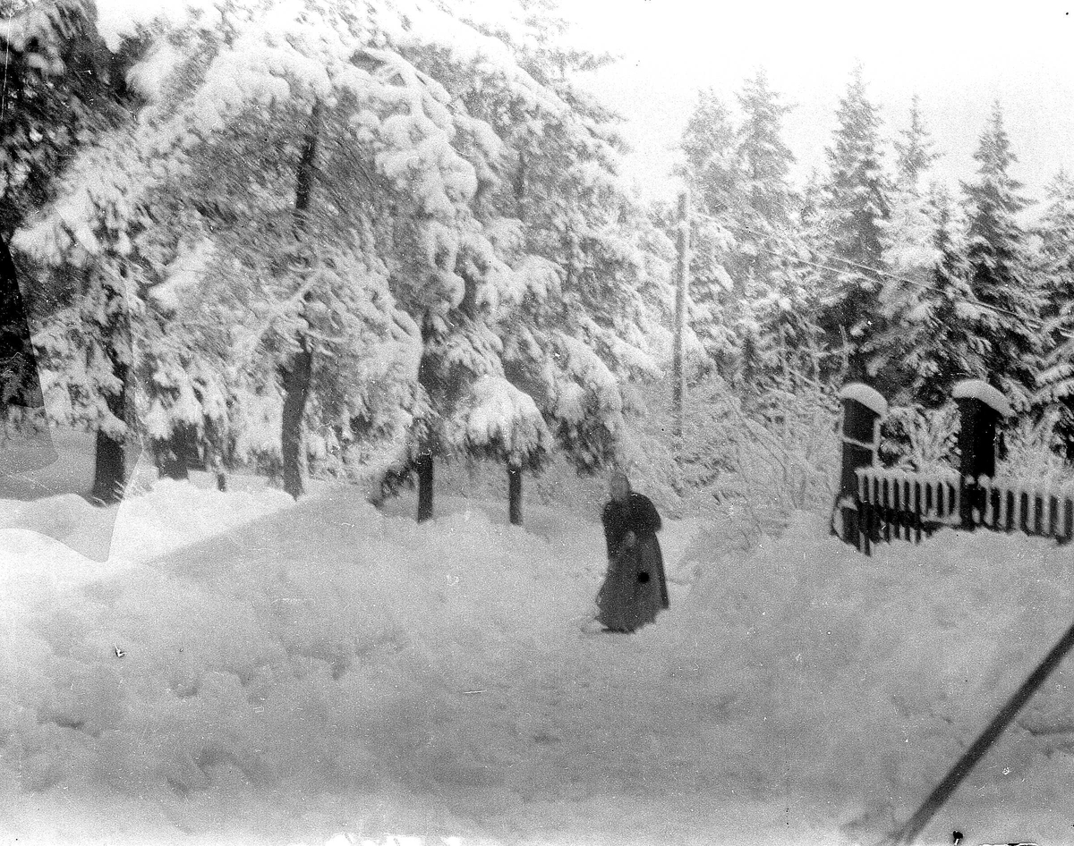 Juliane Fredrikke Langberg, Vinterbilde med kvinne som ant. rydder veien for snø. Gjerde med port t.h. Fra malerinne Juliane Fredrikke Langbergs (1856-1930) samling, tatt ca.1895-1910 med motivkrets slekt og venner samt steder tilknyttet samvær med disse.