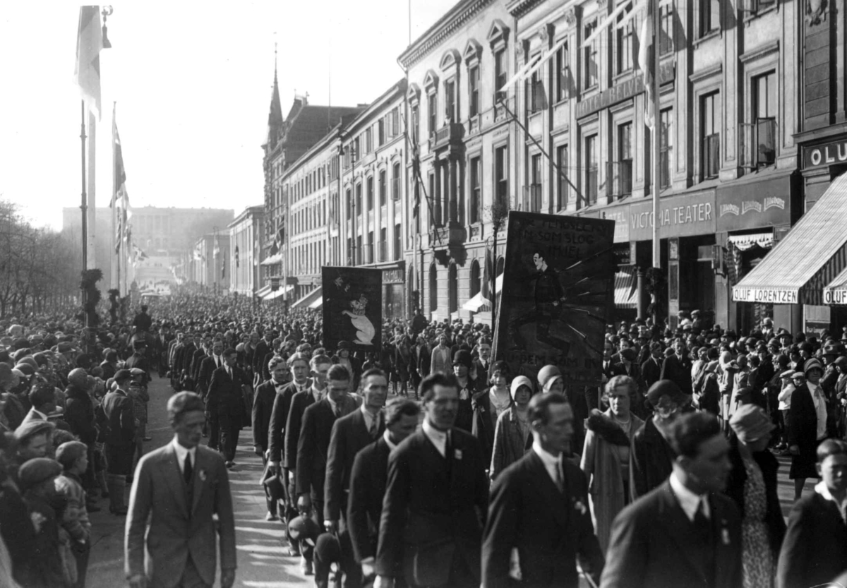 Hermann Christian Neupert, 1. mai-tog, Karl Johans gate. 1930. Menn og kvinner. Faner. Flagg. Slottet i bakgrunnen.
