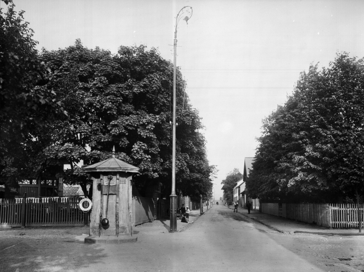 Samuel Lindskog, Nygatan österut från Västra gatan. Bostadshus. Vattenpump till vänster på bilden. Reproduktion efter en bild tagen omkring 1905.