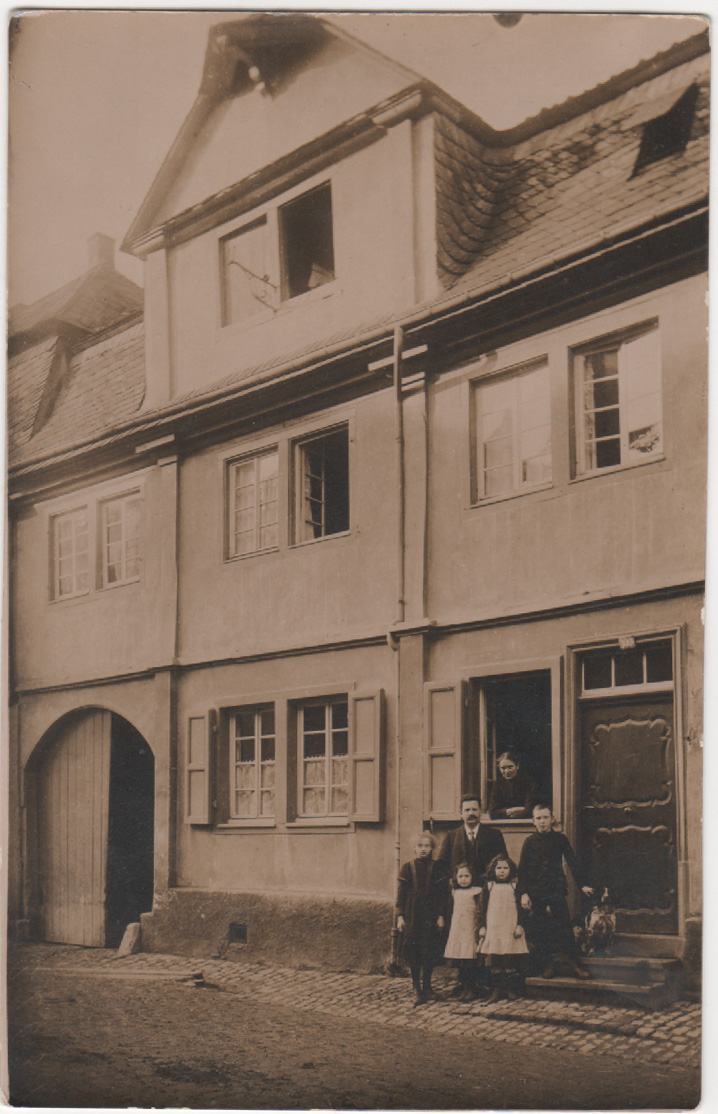 Unknown artist, Lehrer Mies mit Familie vor dem Wohnhaus
