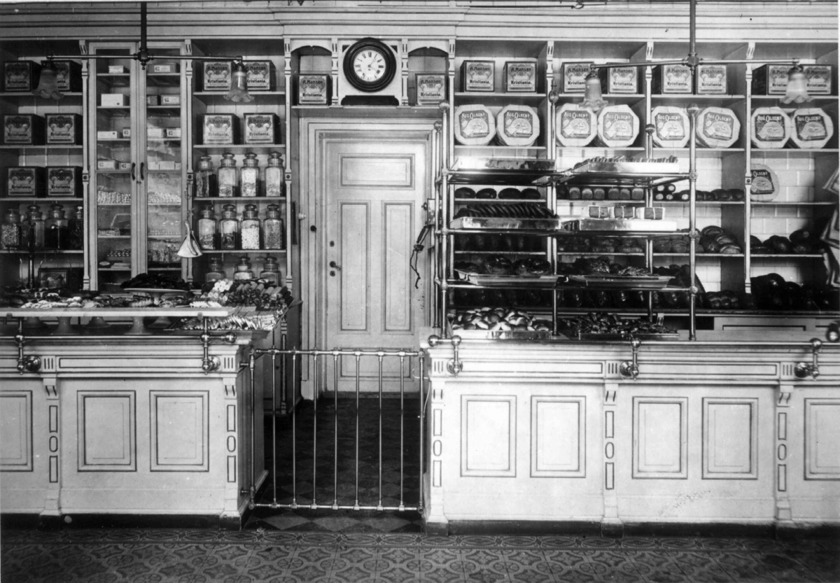 Narve Skarpmoen, A. Hansens Bakeri, Bogstadveien 54, Oslo, 1913. Interiør fra butikken med disker og hyller med varer.