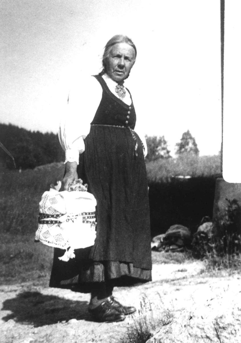 Anna Grostøl, Kvinne som bærer på sending, en tine med klede rundt. Ukjent sted 1935.