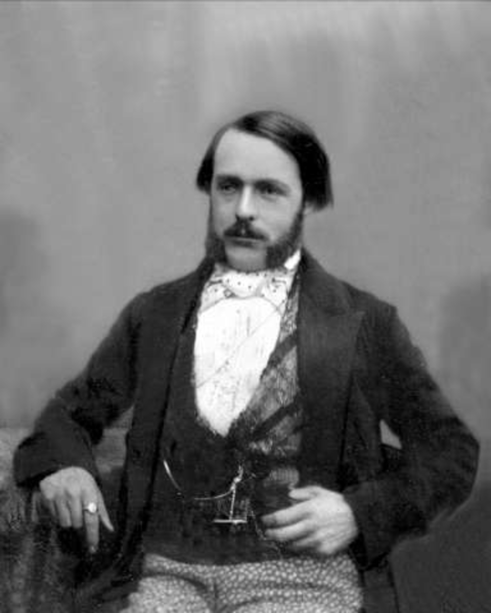 Gustav Borgen, Portrett, mann i motedrakt. Plysjvest, prikkete bukser, mørk jakke og hvit skjorte med tørkle i halsen. Signet(?)ring på høyre pekefinger, klokkekjede mm.