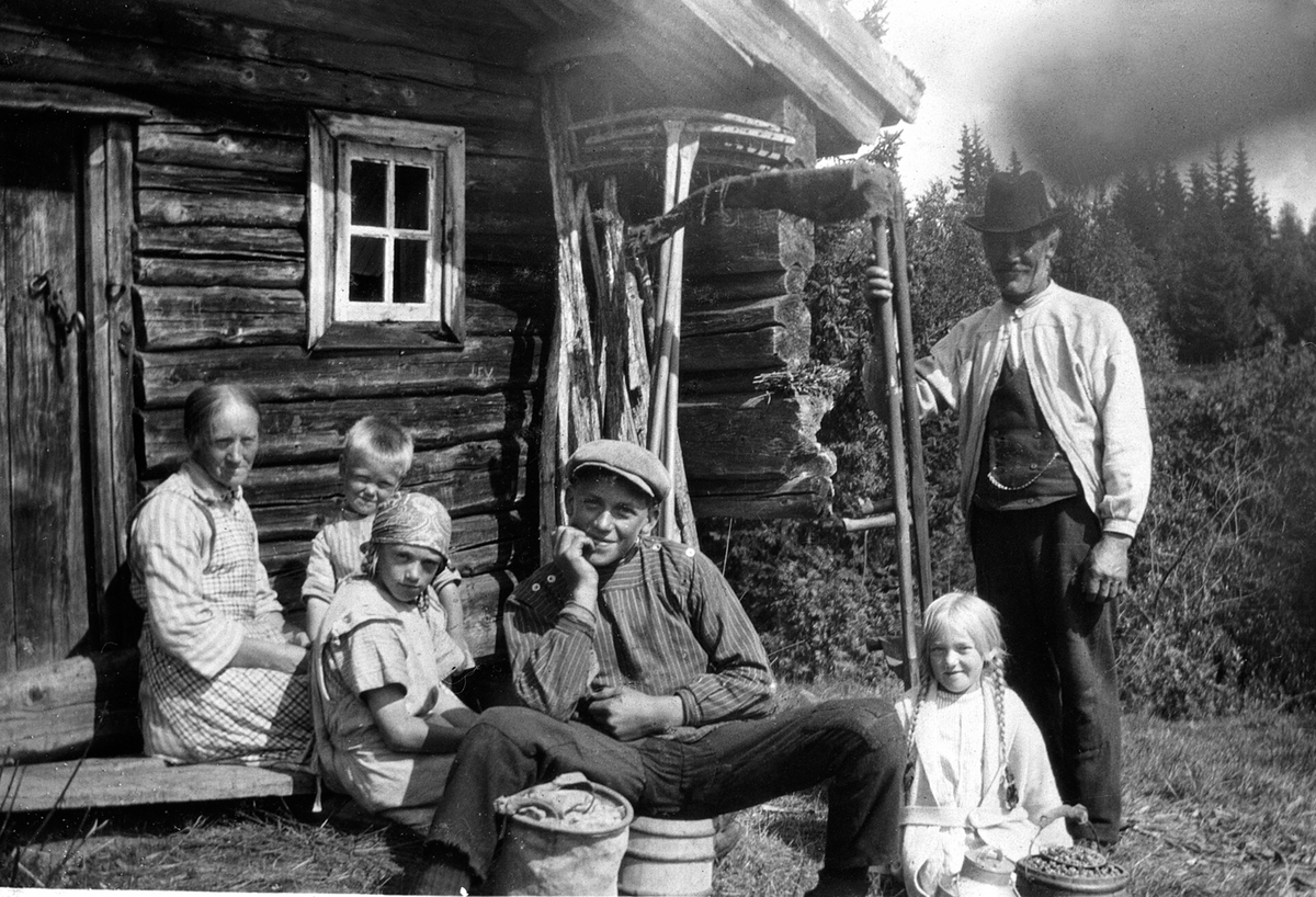 Anno Domkirkeodden, SLÅTTONN, HØYONN PÅ SAVALSETRA, GR: 6 VOKSNE OG BARN FORAN STØR-HUSET, FRA V:GØNNER SKJELBEK, EIVIND SKJELBEK, SIGVART SKJELBEKBarna til Gønner og Sigvart.