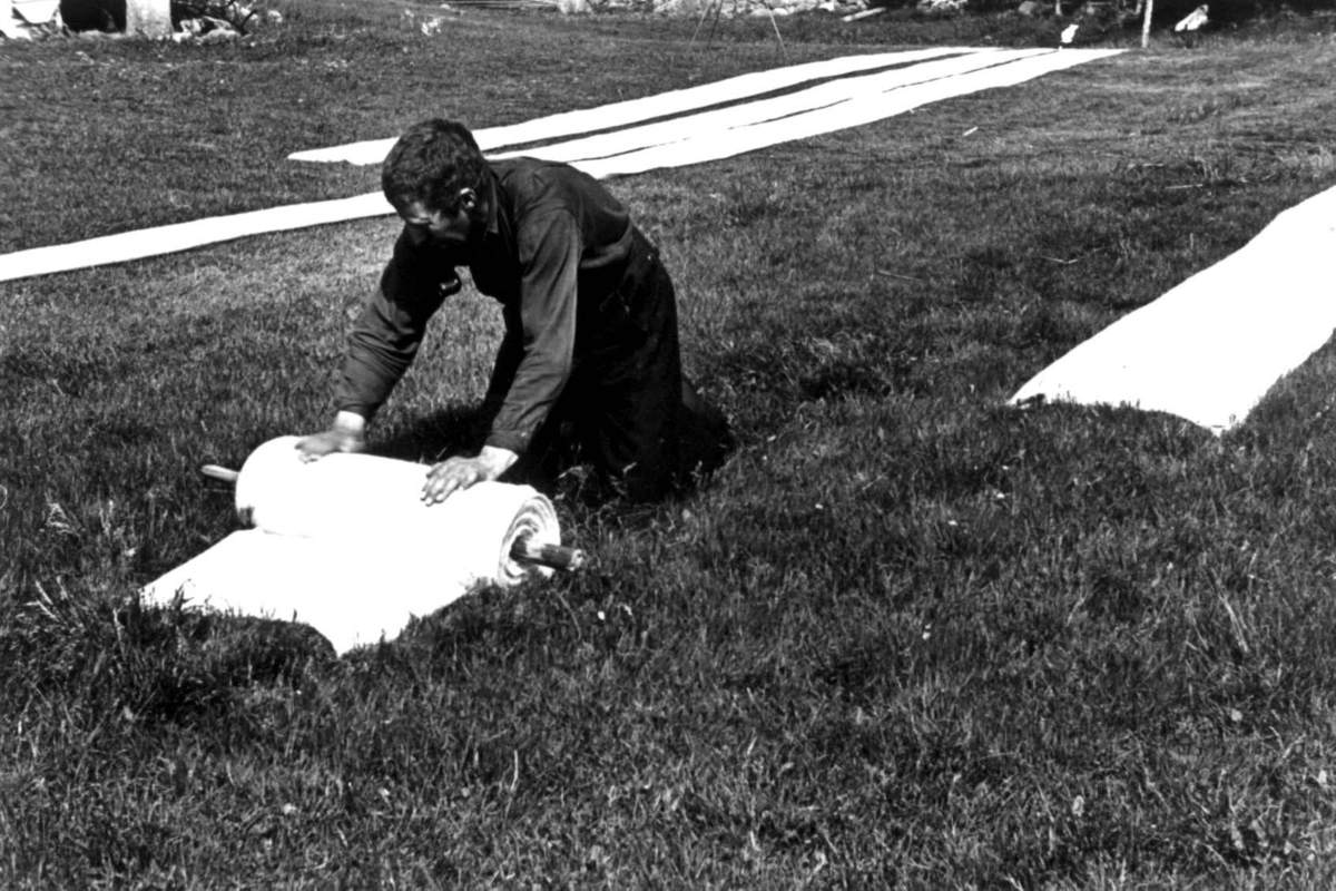 Anna Grostøl, Valle, Setesdal, Aust-Agder 1939. Lavrans Homme ruller vadmel på en stokk.