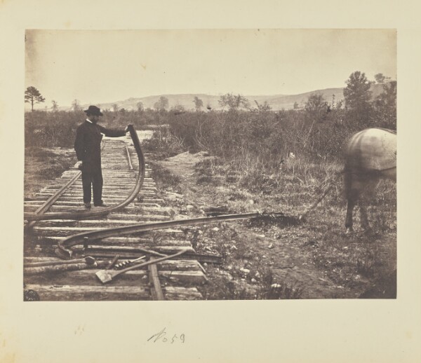 A. J. Russell, [Man holding bent rail]