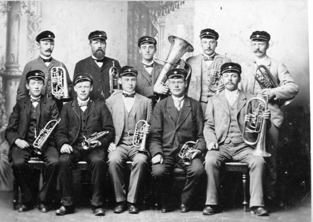 Anno Domkirkeodden, 10 musikere med instrumenter. Nordåsen musikkorps. Fra venstre er baker Kristian Ludvig Kristiansen, dirigent Fredrik Græsby, ukjent, Maurud, ukjent. Bak fra venstre er skomaker Olsen, skomaker Johan Nilsen, Kristoffer Bjørnerud, Mathias Neråsen, baker Lars Andersen. Brumunddal.