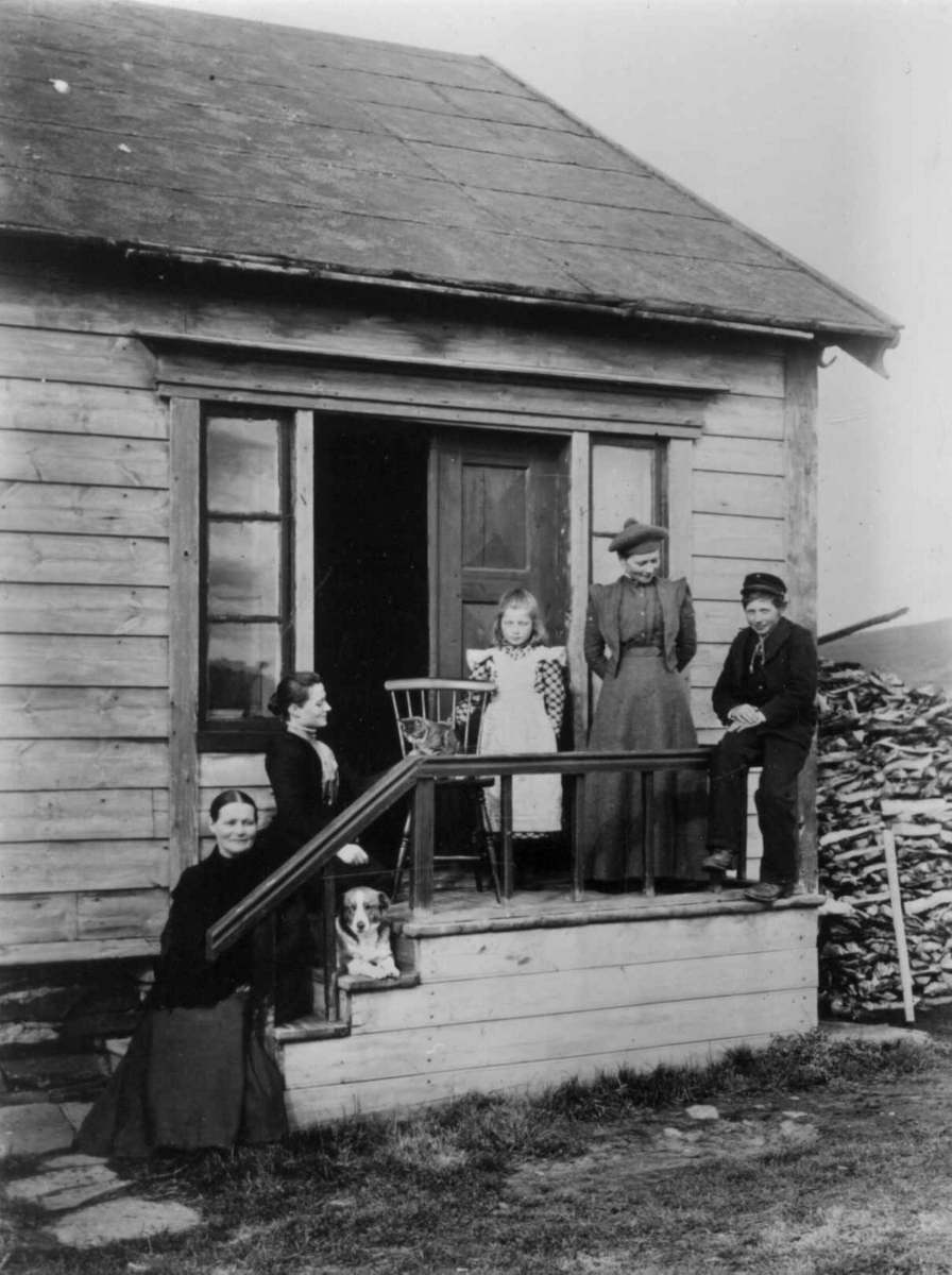 Ellisif Rannveig Wessel, Portrett av kona til lærer Thomas Lilleeng med to døtre, fosterdatter og gutt ved inngangspartiet til deres bolig, Vestre Jakobselv, Vadsø, Nord-Varanger, Finnmark,1890-årene.