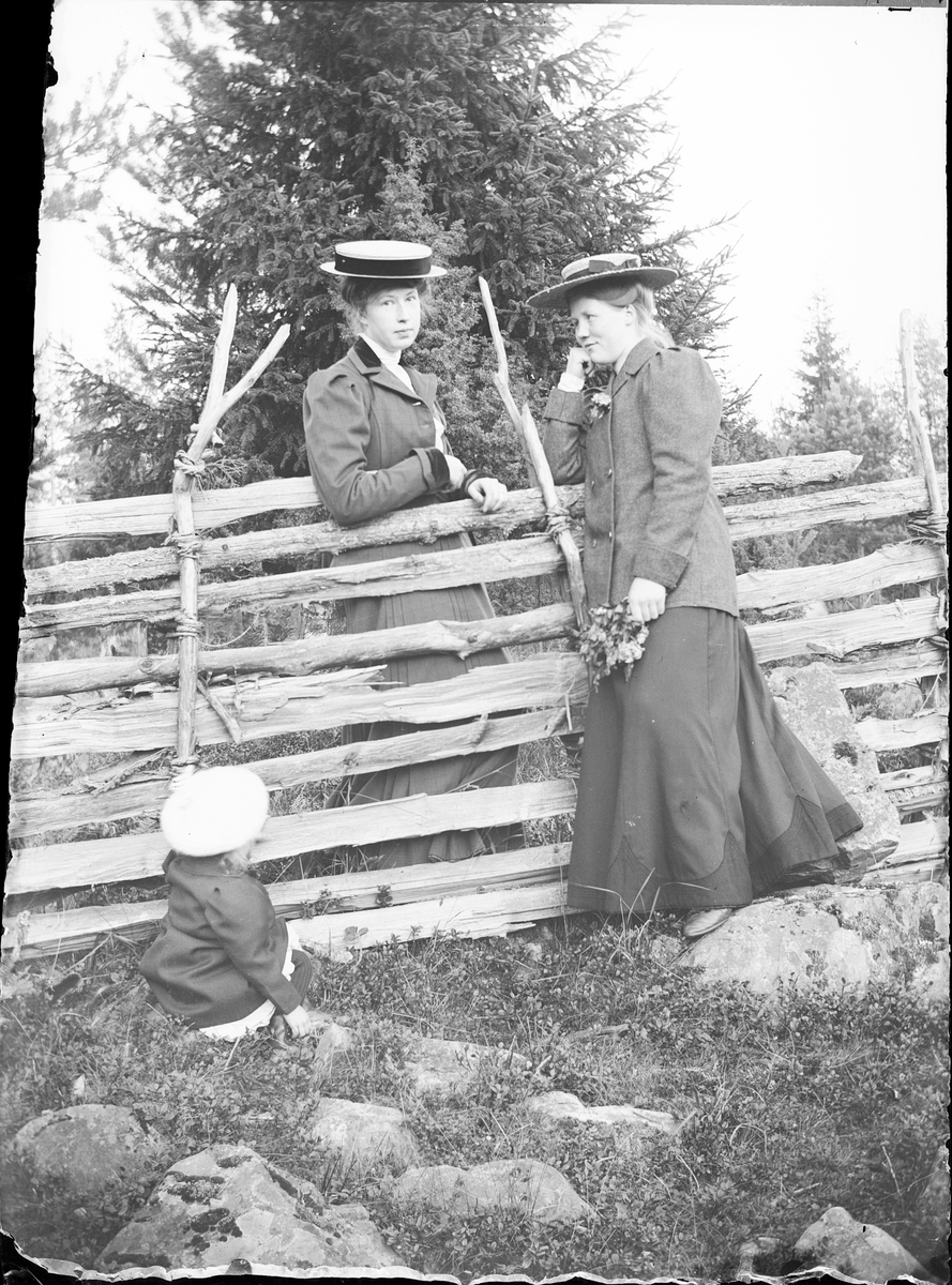 Skötsner-Edhlund, Kvinna står med Ruth Skötsner vid gärdesgården och ett barn sitter på marken, Östhammar Uppland