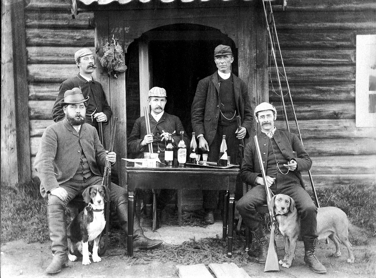 Anno Domkirkeodden, JAKTLAG I SKOGER, NR. 4 FRA VENSTRE: EMBRET SKOGEN, NR. 5 : FABRIKKBESTYRER PÅ MELKEFABRIKKEN PÅ HAMAR: H. D. FABRICIUS, HAREHUND OG GEVÆR, ALKOHOL