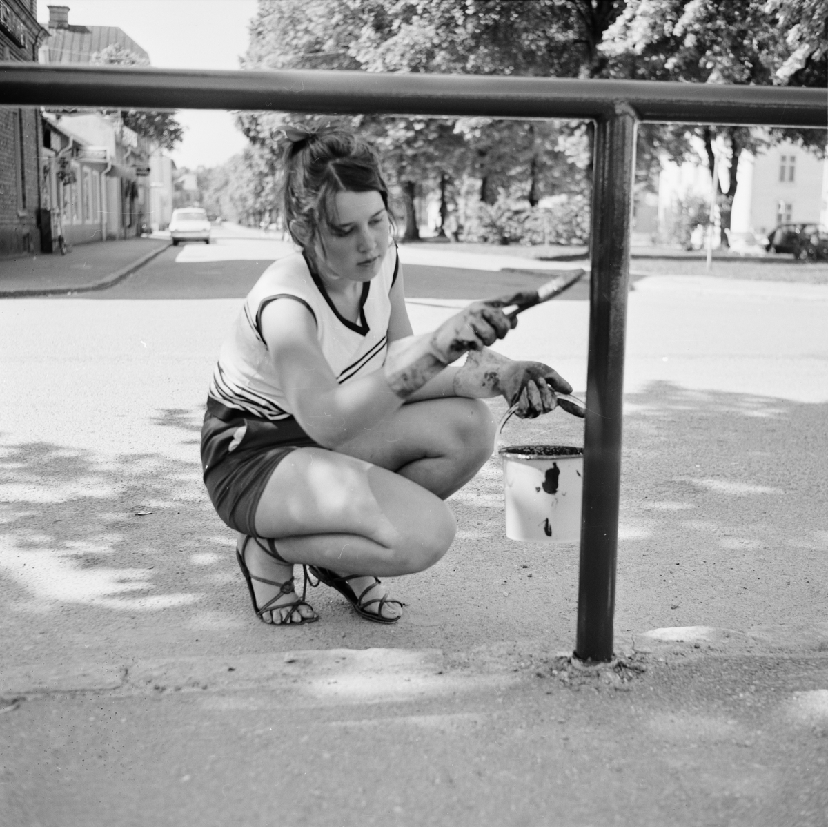 Tierp Arbetarbladet, Anneli Morberg målar staket under sitt feriearbete hos Tierps köpings parkavdelning, Tierp, Uppland juni 1968