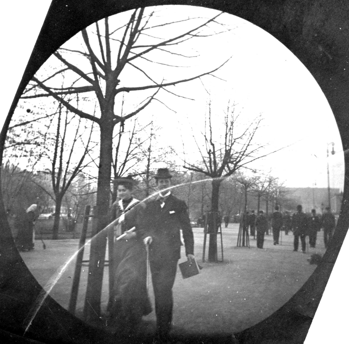 Fredrik Carl Mülertz Størmer, Frk. Signe Hvistendahl og Herman Reimers spaserer langs Karl Johan, Oslo, med bøker i hånda. Slottet skimtes.