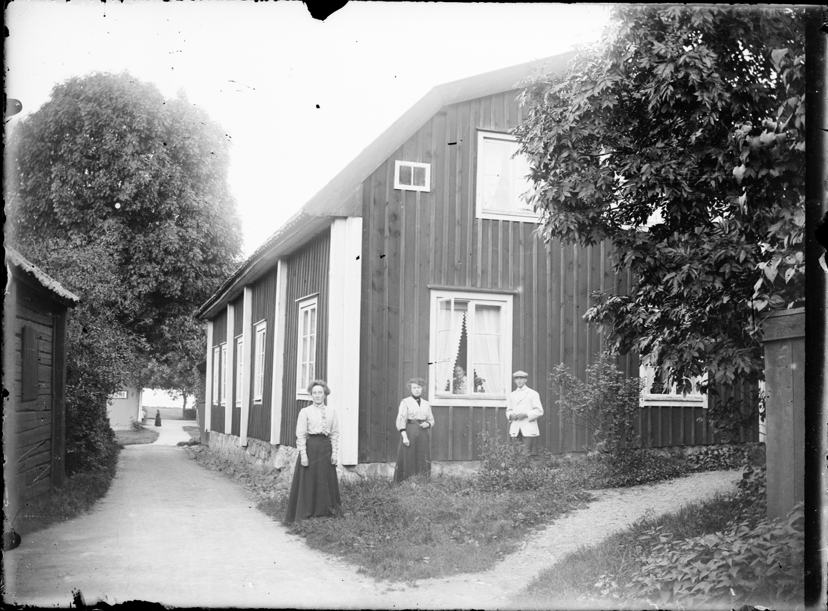 Skötsner-Edhlund, Man and women outside residential buildings, Sjögatan, Östhammar, Uppland