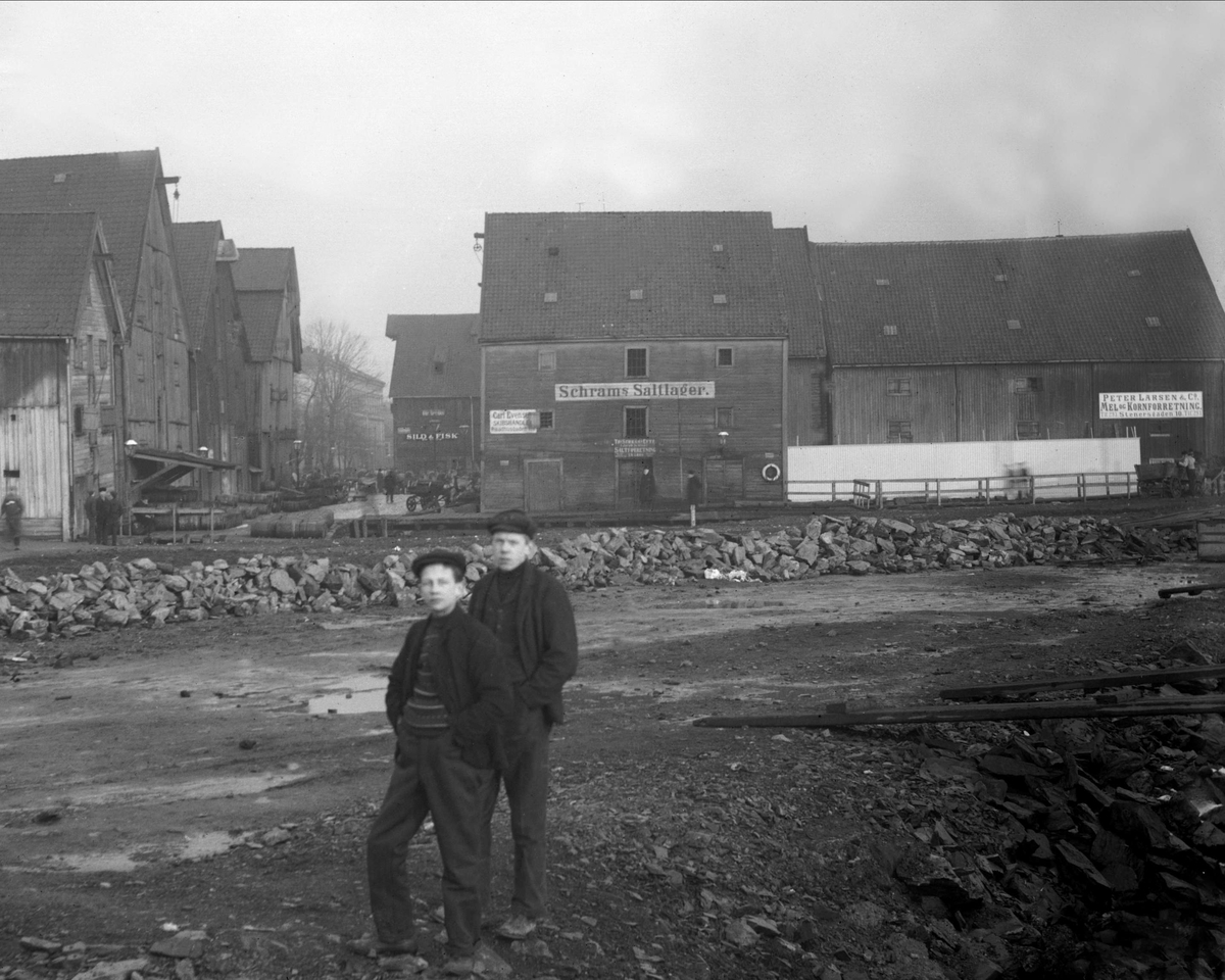 Gustav Borgen, To gutter i strandkanten ved lavvann. Lagerbygninger i bakgrunnen. Schrams saltlager og Peter Larsen & Co Mel- og kornforretning. BIlder tatt for grosserer O Halvorsen.
