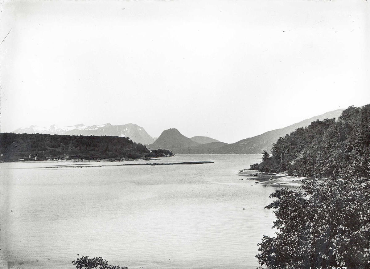 Tom Kent, Landskap med vann, skog og snøtoppede fjell.