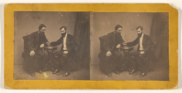Unknown, [Two men seated, posed at a table in a studio]