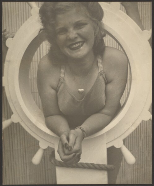 Louis Fleckenstein, [Woman Posing in Ship's Wheel]