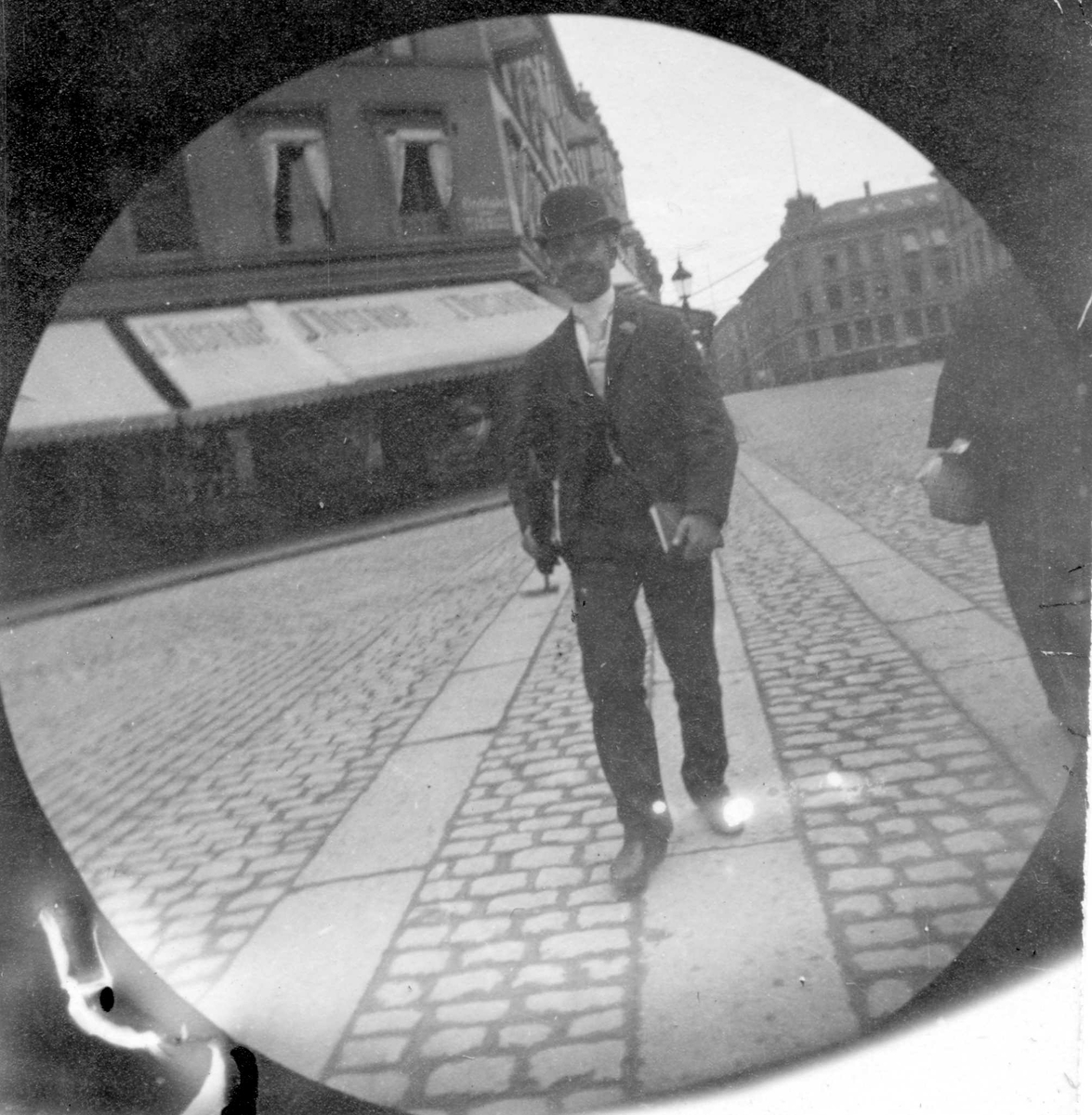 Fredrik Carl Mülertz Størmer, Herman Reimers spaserer langs Karl Johan, Oslo, ved Tostrupgården med bok under armen.