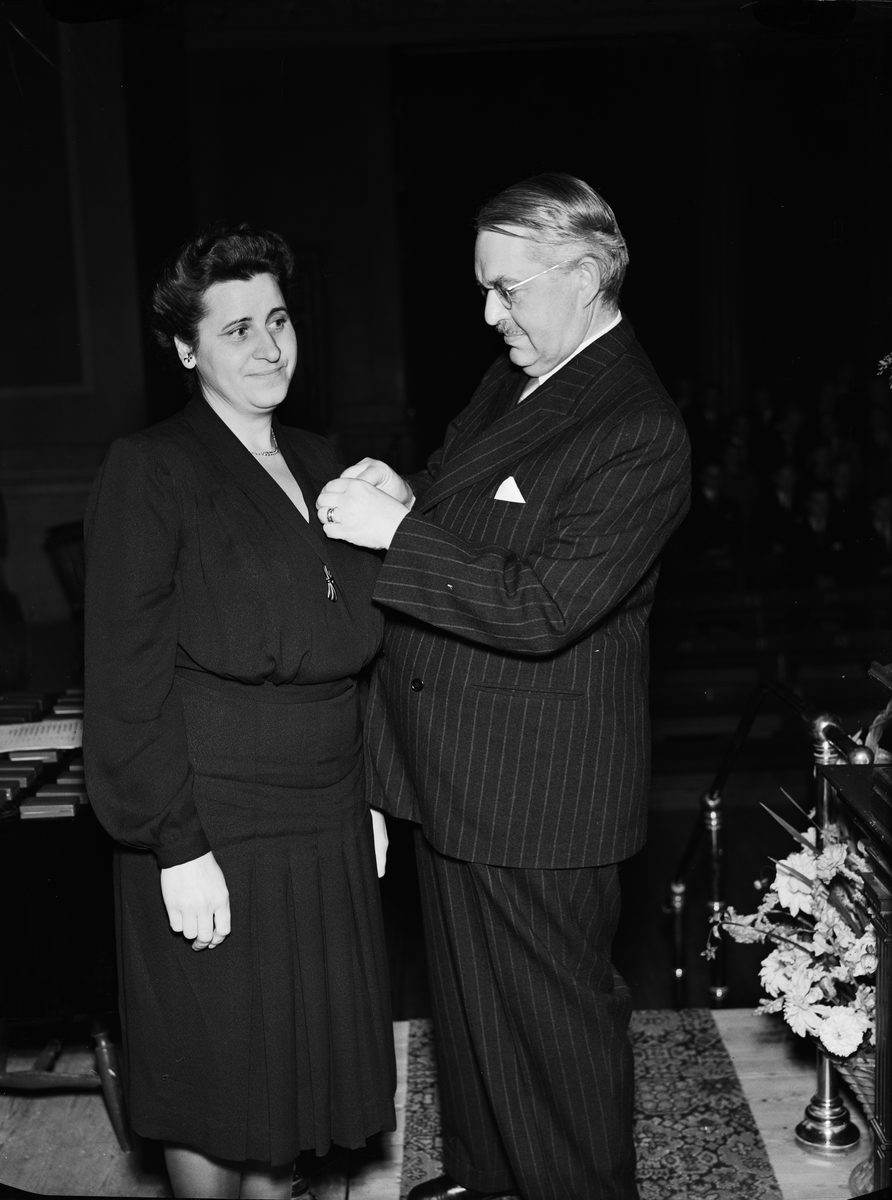 Paul Sandberg, Kvinna får medalj av landshövding Hilding Kjellman, sannolikt i universitetsaulan, Uppsala augusti 1946