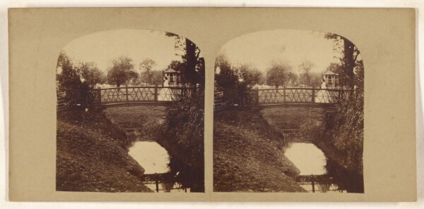 Unknown, [Woman crossing footbridge over stream]