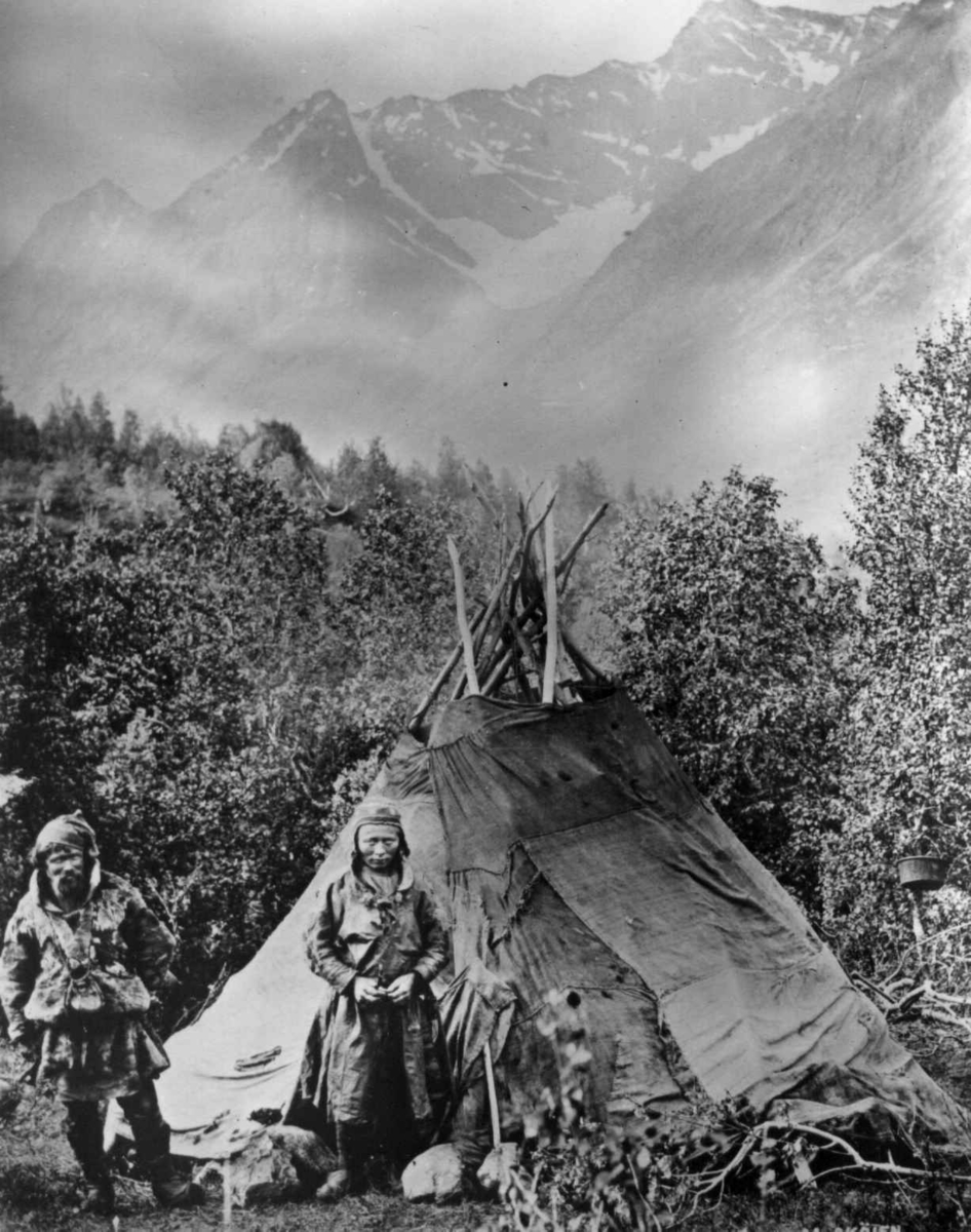 Marthinius Skøien, Samer, antagelig fra Karesuando, Lyngseidet, Lyngen, Troms, muligens 1890-årene. Mann og kvinne poserer foran telt.
