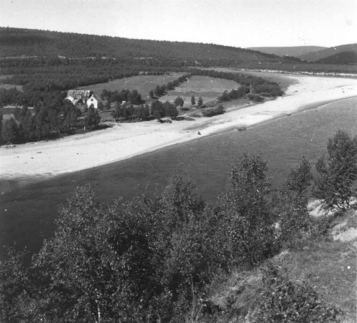Virginia Raymond Davidson, Oversiktsbilde over del av Tanaelva, muligens nær utløpet, med bygninger på motsatt side, 1961.
