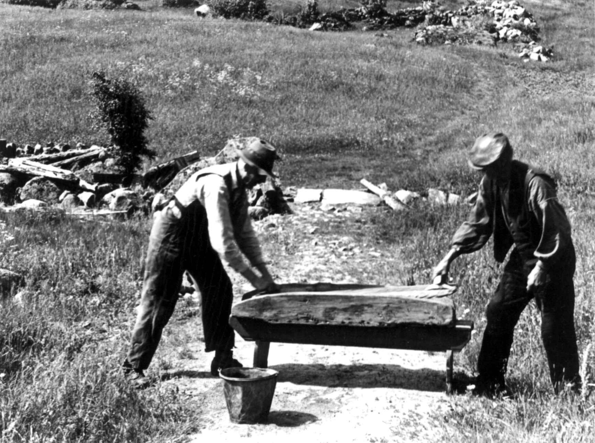 Anna Grostøl, To menn ved en stampe til tøy. Fjotland, Kvinesdal, Vest-Agder 1941.