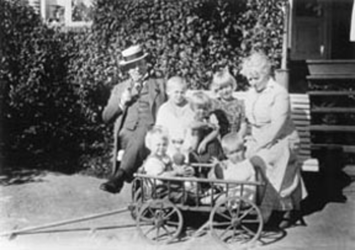 Anno Domkirkeodden, Doktor Karl Løken og Thora Løken med fem barnebarn for huset på Granerud gård, Brumunddal. Lekevogn.