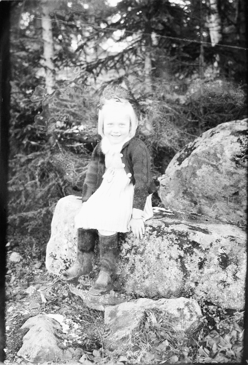 Håkon Prestkværn, Ukjent jente på en stein i skogen. Fotokonvolutt mrk. "Jarle Olsen okt. 1948"