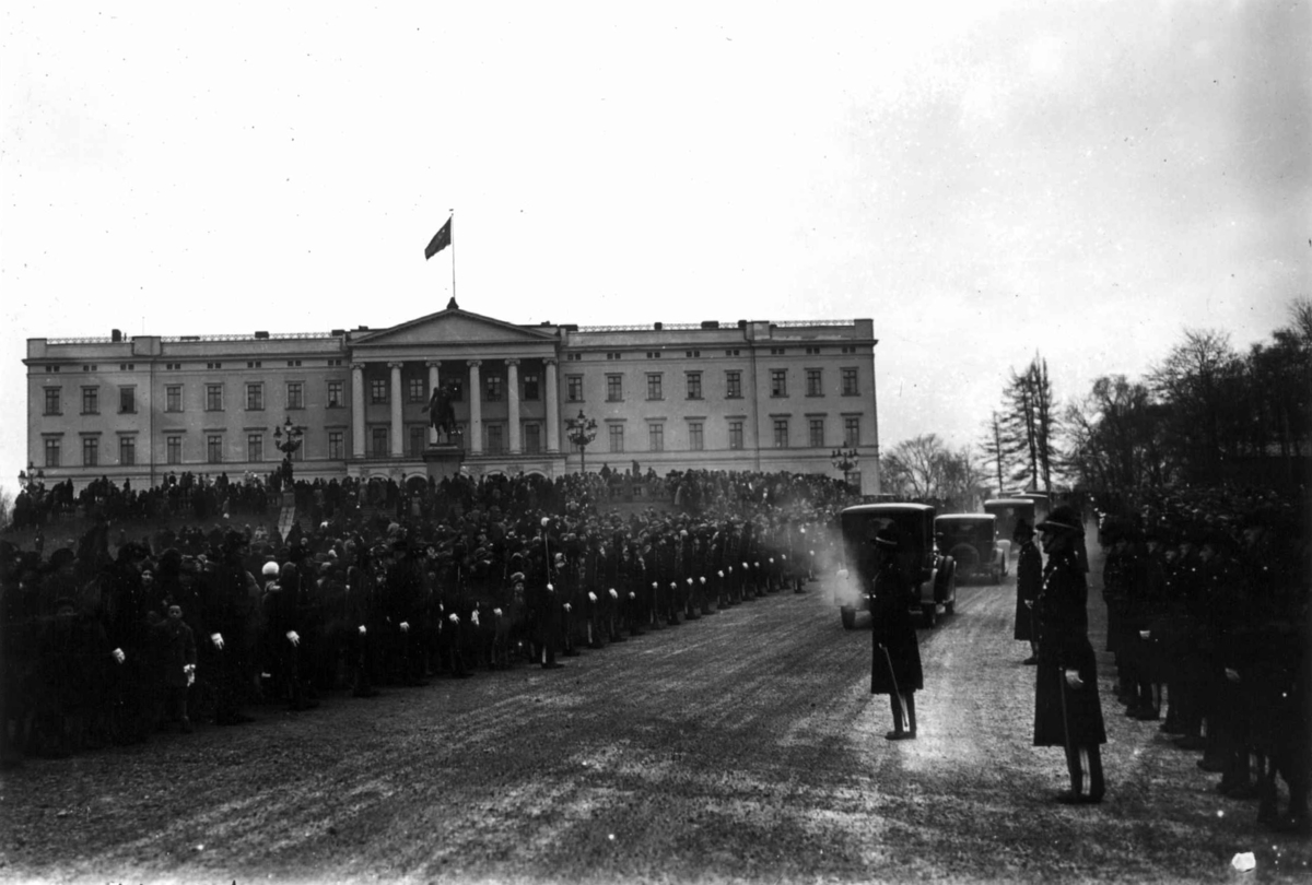 Hermann Christian Neupert, Håkon VII's 25. års jubileum, Karl Johans gate i Oslo. 1930. Oppstilte soldater og offiserer. Bilkortesje på vei til slottet. Publikum. Slottet i bakgrunnen.