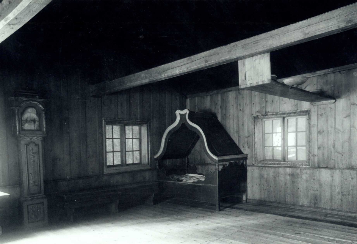 Gisle Midttun, Hofsløkka, Elverum, Sør-Østerdal, Hedmark. Interiør fra stua med seng, benk og golvklokke. Nå på Glomdalsmuseet.