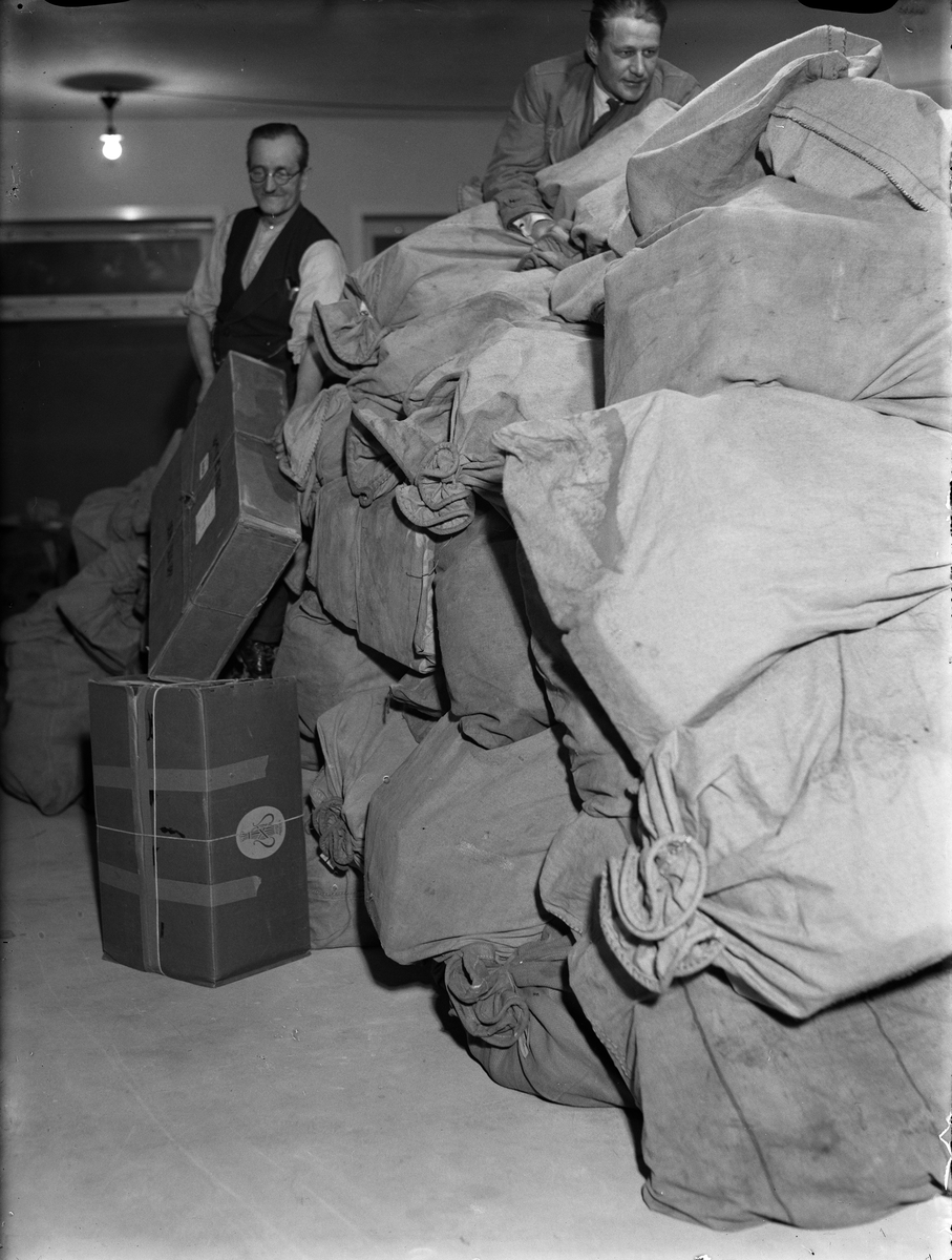 Paul Sandberg, "2,000 julpaket om dagen till Upsala", PJ Strand och Harry Gustafsson bland julpaketsäckarna, Uppsala december 1942
