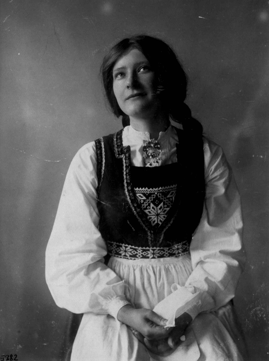 Hermann Christian Neupert, Kvinnedrakt fra Hardanger, Hordaland 1927. Kvinne med brev i hånden.