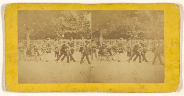 Unknown, [A parade of children, one being pulled in a cart]
