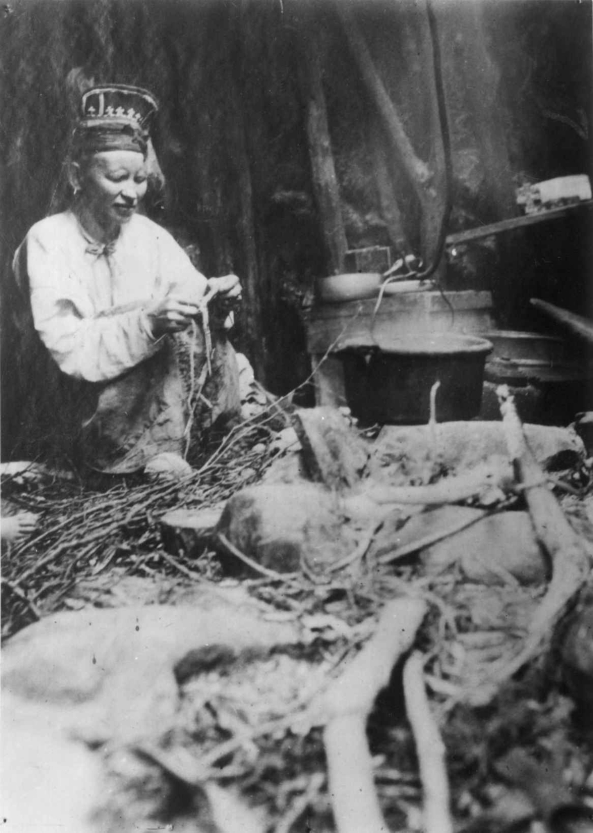Ellisif Rannveig Wessel, Skoltesame-kone, Tajana Feodotova Titoff, strikker ved kokestedet, antatt Sør-Varanger, Finnmark ca. 1900.