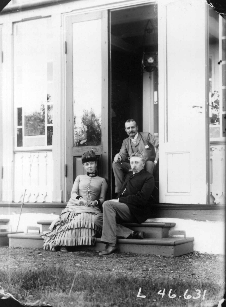Fredrik Emil Faye, Gruppeportrett, på trapp fra venstre fru Sigrid Faye, hennes bror ingeniør Jørgen Dahll, arkitekt Gustav Berg, ca. 1882. Fra portrettserie av personer som bodde på eller besøkte Dal gård, Ullensaker, fotografert av gårdens eier, kammerherre Fredrik Emil Faye (1844-1903) i årene 1875-1900.