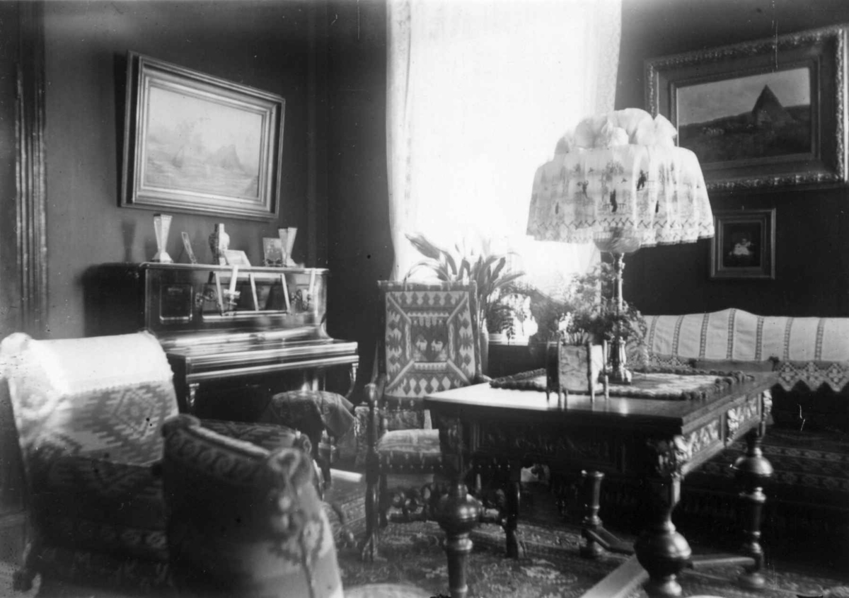 Hermann Christian Neupert, Interiør, ukjent sted. 1908-1010. Stue. Piano. Malerier.