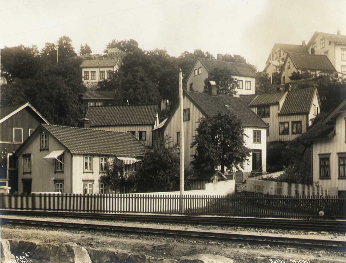 Anders Beer Wilse, Bolighus, Barbu, Arendal, Aust-Agder. Fotografert i 1912. De fleste husene eksisterer fremdeles. Senttralt i bildet er bolighuset Barbu 12. Til venstre sees garver Nævestads bolig, og gavlen på selve garveriet.