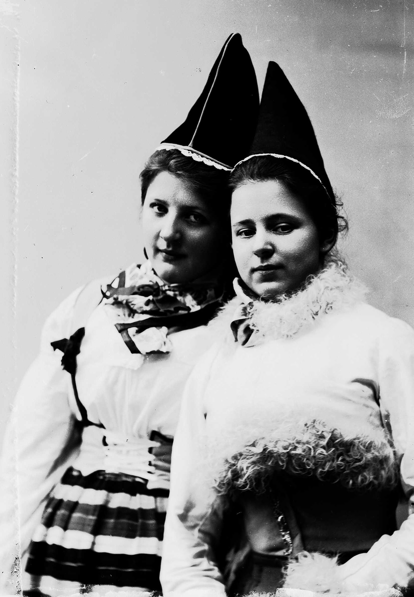 Solveig Lund, To kvinner i drakt og lue.