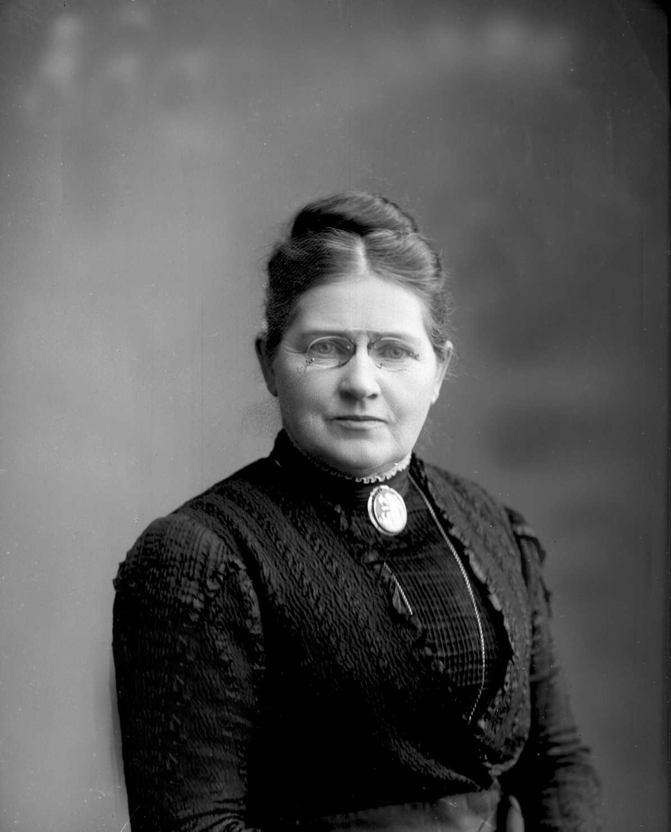 Gustav Borgen, Portrett, kvinne i svart kjole, brosje i halsen. Fru H P Faye.