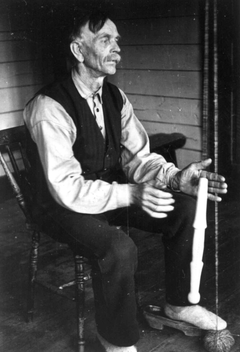 Anna Grostøl, Sigmund Rudlende på Rossevatn spinner på håndrokk. Eiken, Hægebostad, Vest-Agder 1941.