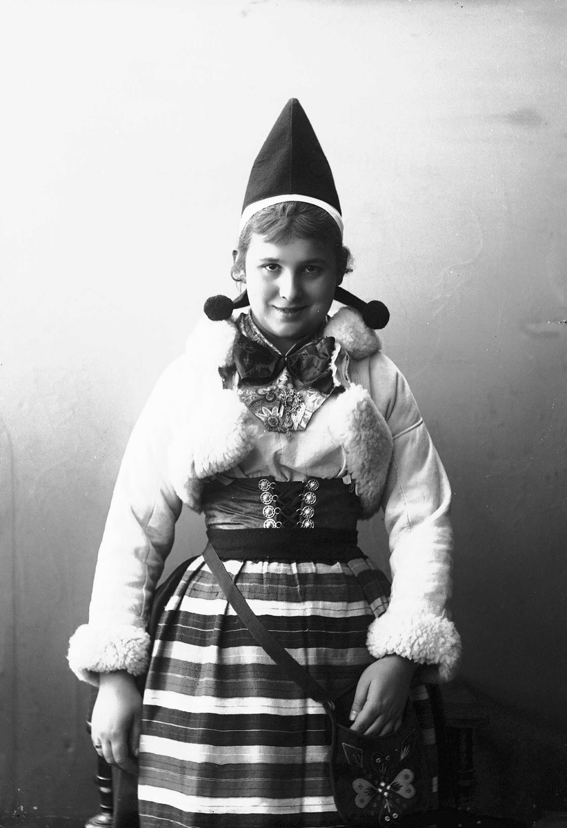 Solveig Lund, Kvinne i drakt - kort skinnjakke med pelskanter og lue.