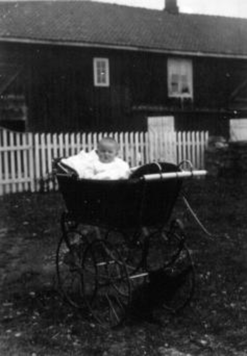 Anno Domkirkeodden, Portrett av barn i barnevogn foran uthus.