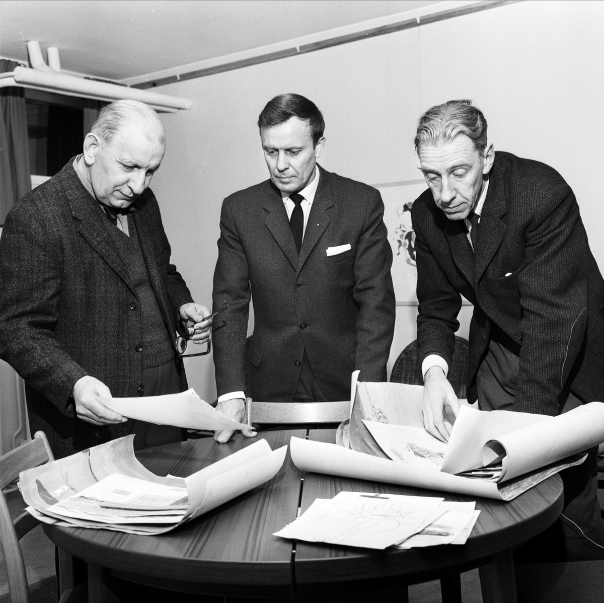 Tierp Arbetarbladet, Tre män tittar på teckningar av "unga tecknare", sannolikt Tierp, Uppland, 1966
