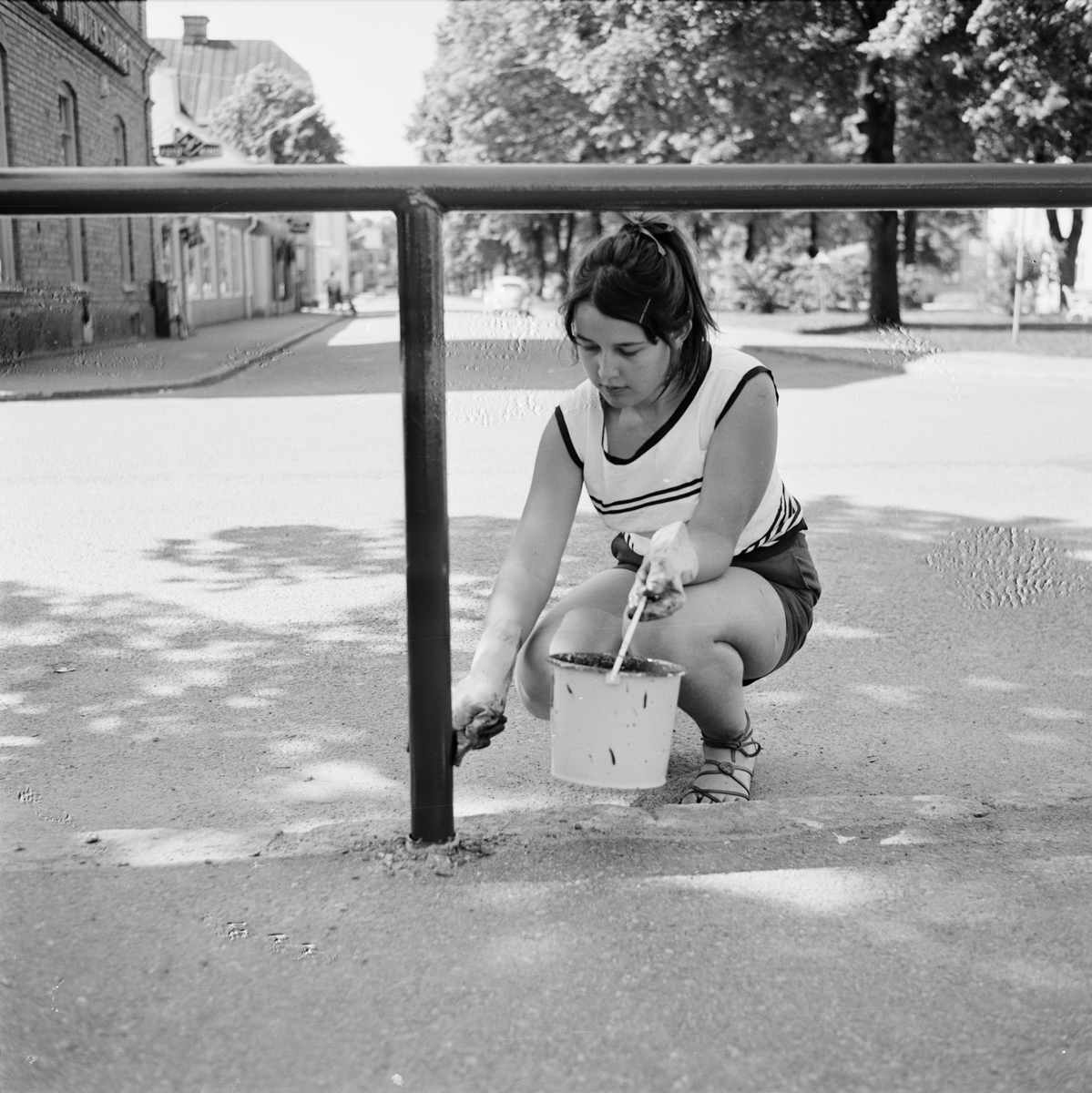 Tierp Arbetarbladet, Anneli Morberg målar staket under sitt feriearbete hos Tierps köpings parkavdelning, Tierp, Uppland juni 1968