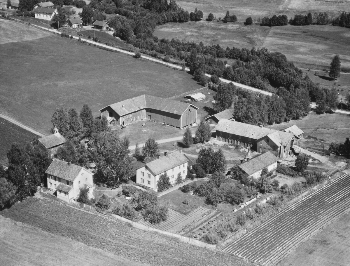 Anno Domkirkeodden, FLYFOTO, KALLERUD GÅRD, FRA VENSTRE: FØDERÅDSBYGNING, HOVEDBYGNING, DRENGESTUE MED VERKSTED, SKÅLE, BRYGGERHUS, FJØS, LÅVE, STABBUR.