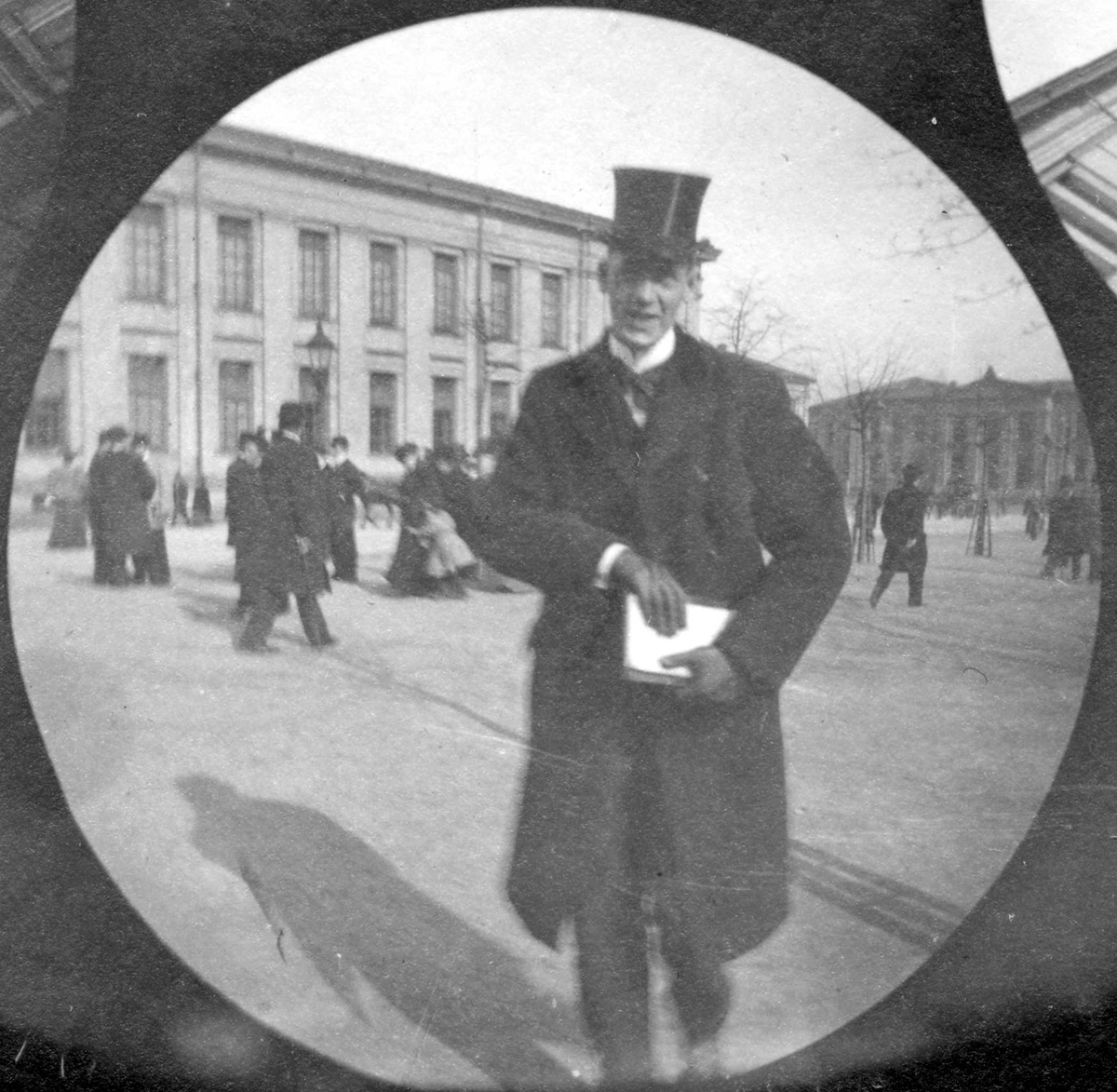 Fredrik Carl Mülertz Størmer, Oluf Wengaard, student fra 1892, står på Universitetsplassen, Oslo, med flosshatt og bok under armen.