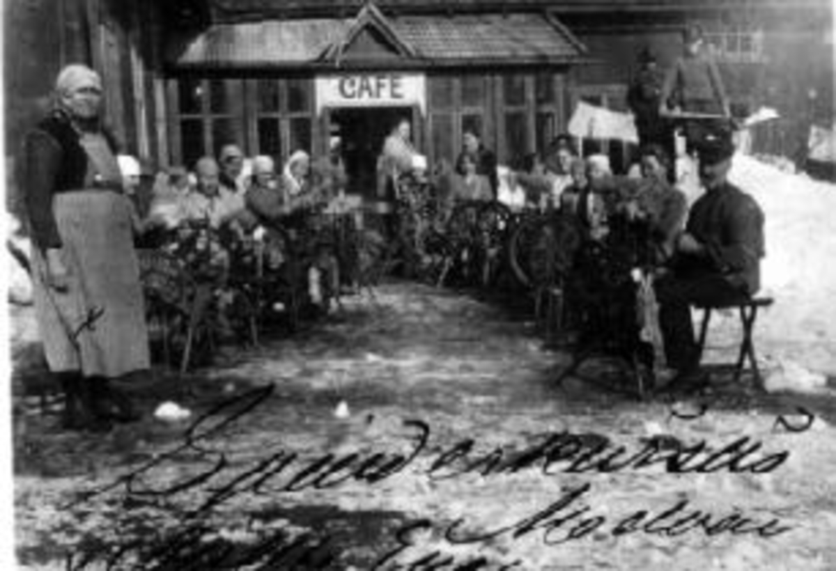 Anno Domkirkeodden, Stor gruppe damer og en mann på spinnekurs på Strømsgård, Moelv.Til venstre er Alethe Eng, til høyre er Olaf Berglund. Inngang til cafe i bakgrunnen.
