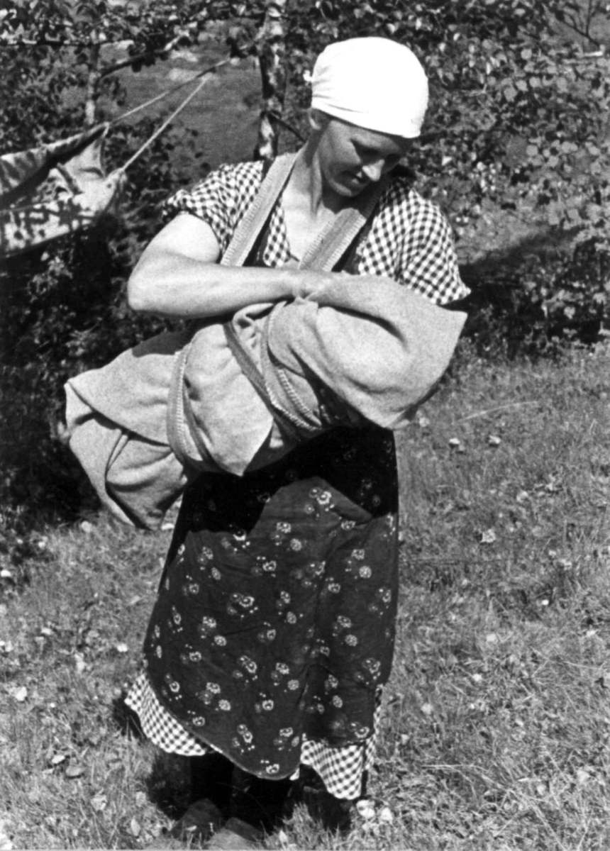 Anna Grostøl, Ingeborg bærer et barn i linde på Engedal. Fjotland, Kvinesdal 1941.